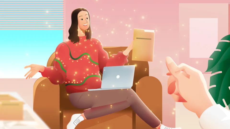 Frau im leuchtenden Weihnachtspullover sitzt mit Laptop im Sessel und reicht jemandem einen Ordner.