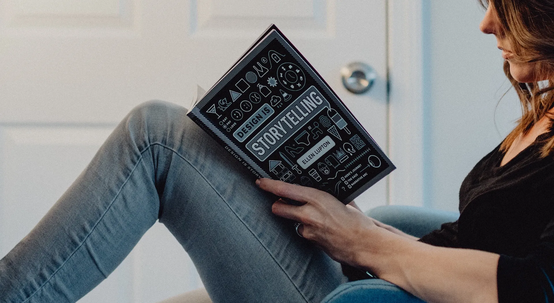 Frau auf dem Sofa liest das Buch «Design is Storytelling» von Ellen Lupton