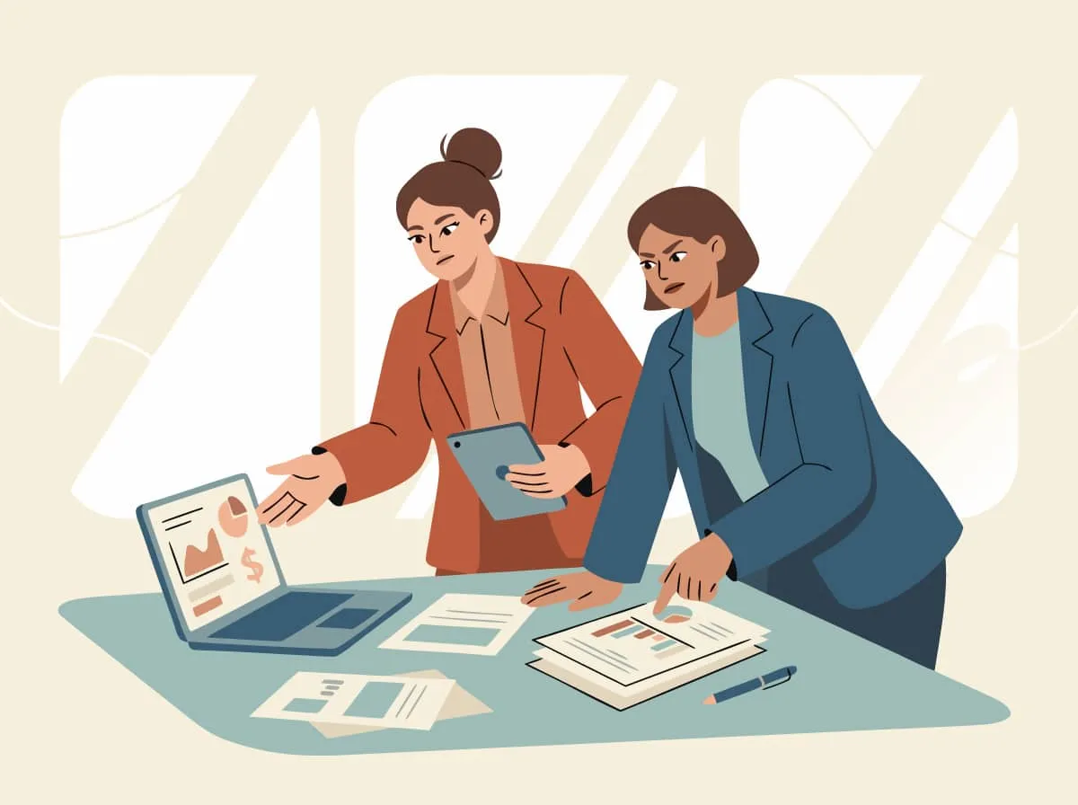 Zwei Frauen beugen sich über Laptop und Auswertungen und diskutieren skeptisch über die Zahlen.